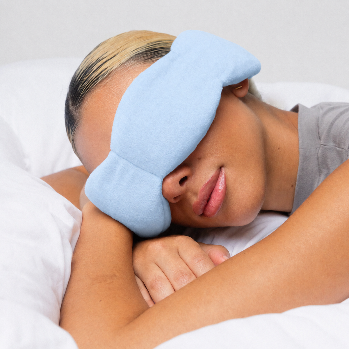 Woman wearing the Dozzli weighted sleep mask in bed